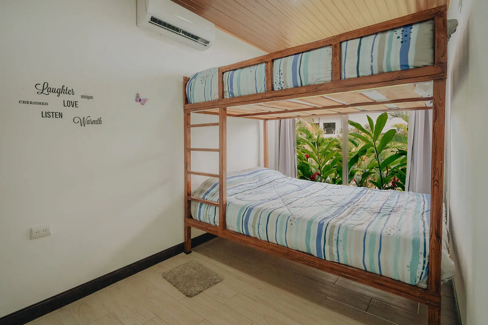 Habitación con camarote de madera y ventana al jardín tropical